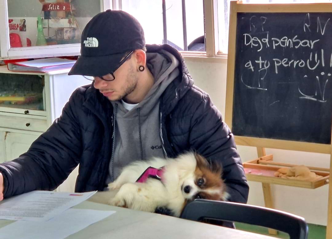 Alumno de Ciudadano Can estudiando con un perro en brazos